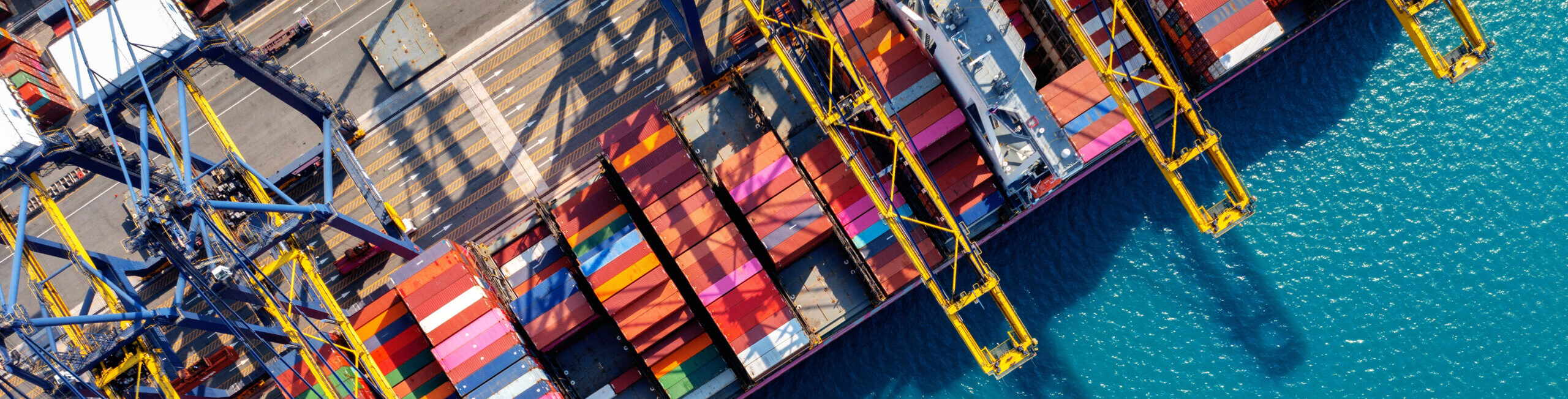 Aerial view of cargo ship and cargo container in harbor.